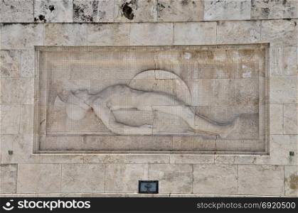 Tomb of the unknown soldier marble sculpture of dying ancient greek hoplite warrior holding his shield and spear, Athens Greece.