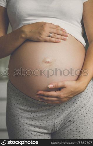 Toned closeup photo of young pregnant woman on the 9 month