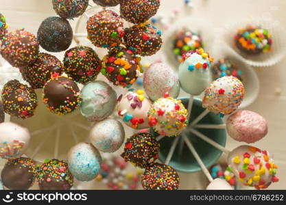 Toned image of decorated cake pops and candies on table