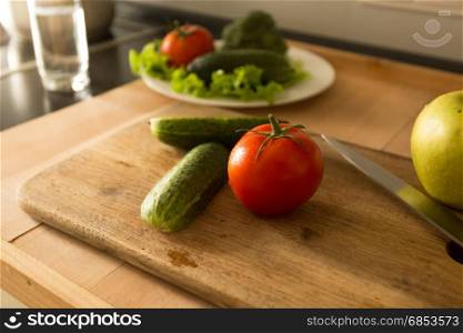 Toned photo from top of vegetables and fruits lying on wooden board at kitchen