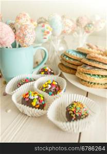 Toned photo of colorful candies, cup and cookies on table at cafe