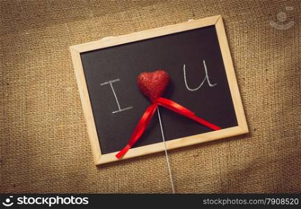 Toned photo of red heart in declaration of love on blackboard