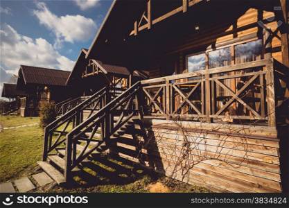Toned photo of traditional wooden cottage with big terrace