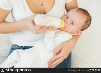 Toned portrait of adorable baby boy drinking milk from bottle