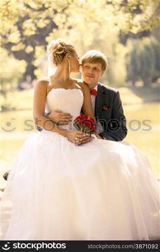 Toned portrait of happy bride and groom hugging at the river bank