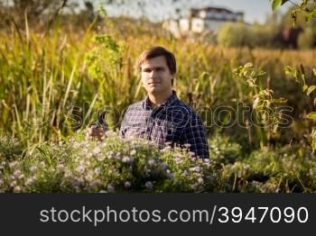 Toned portrait of man working at garden and cutting flowers