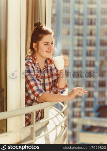 Toned portrait of woman smoking cigarette and drinking coffee