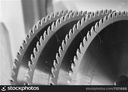 Tool for woodworking, a segment of circular saws with carbide brazing for cutting wood close-up, black and white image.. Segment of circular saws for cutting wood closeup.