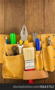 tools and instruments in belt on wood. tools and instruments in belt on wooden background