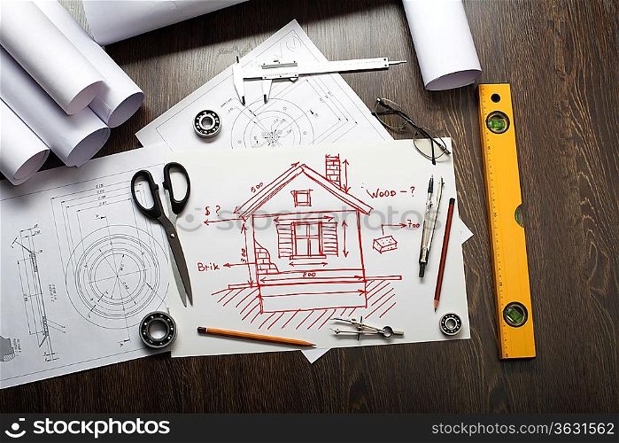 Tools and papers on the table with a picture of a house