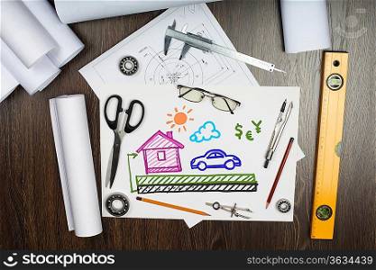 Tools and papers on the table with a picture of a house