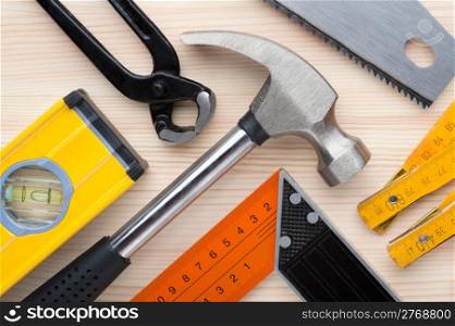 Tools background. Assorted construction and measurement tools arranged on a wooden surface. Construction, repair or home improvement background.
