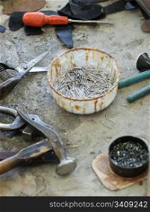 Tools for footwear and a bowl of nails