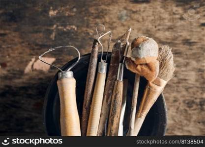 Tools for forming clay on  wooden background. 