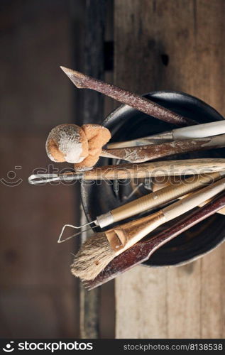 Tools for forming clay on  wooden background. 