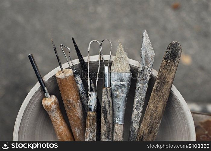 Tools for forming clay with pots in background , selective focus. Tools for forming clay with pots