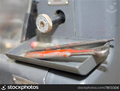 Tools on an offset printing press and a control knob.