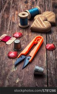 tools seamstresses on wooden background.the image is tinted in vintage style