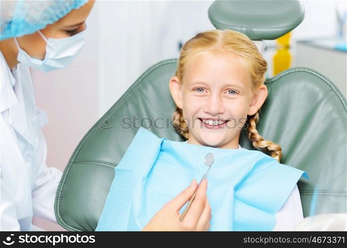 Tooth check. Cute smiling girl in at dentist sitting in armchair