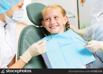 Tooth check. Cute smiling girl in at dentist sitting in armchair