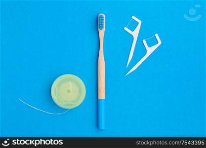Toothbrush and oral care tools over blue background top view copy space flat lay. Tooth care, dental hygiene and health concept.