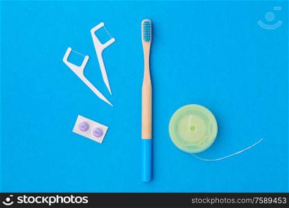 Toothbrush and oral care tools over blue background top view copy space flat lay. Tooth care, dental hygiene and health concept.