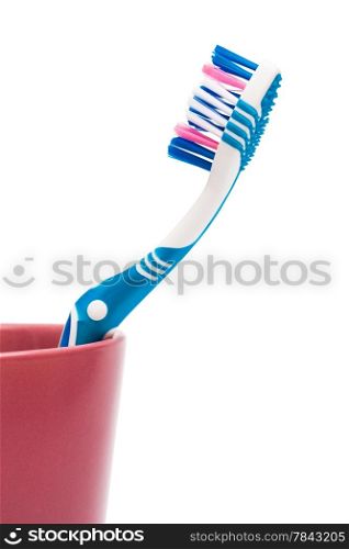 Toothbrush in a red glass on a white background