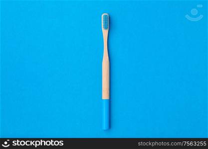 Toothbrush on blue background top view copy space. Tooth care, dental hygiene and health concept.