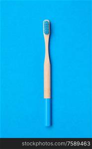 Toothbrush on blue background top view copy space. Tooth care, dental hygiene and health concept.