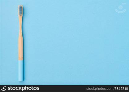 Toothbrush on light blue background top view copy space. Tooth care, dental hygiene and health concept.