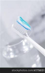 Toothbrush with some toothpaste and a glass of water