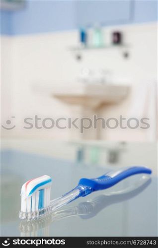 Toothbrush with toothpaste in bathroom