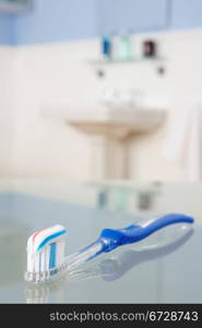 Toothbrush with toothpaste in bathroom