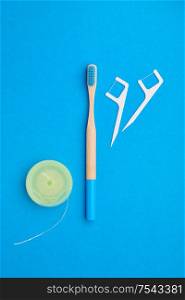 Toothbrushes and oral care tools over blue background top view copy space flat lay. Tooth care, dental hygiene and health concept.