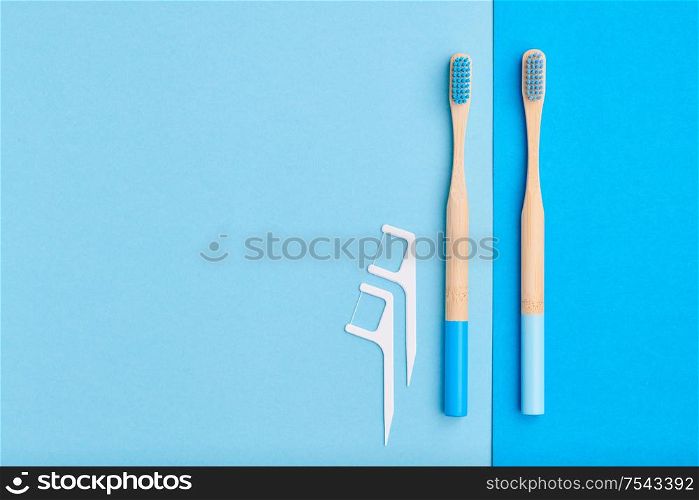 Toothbrushes and oral care tools over blue background top view copy space flat lay. Tooth care, dental hygiene and health concept.
