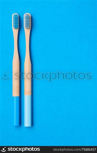 Toothbrushes on blue background top view copy space. Tooth care, dental hygiene and health concept.