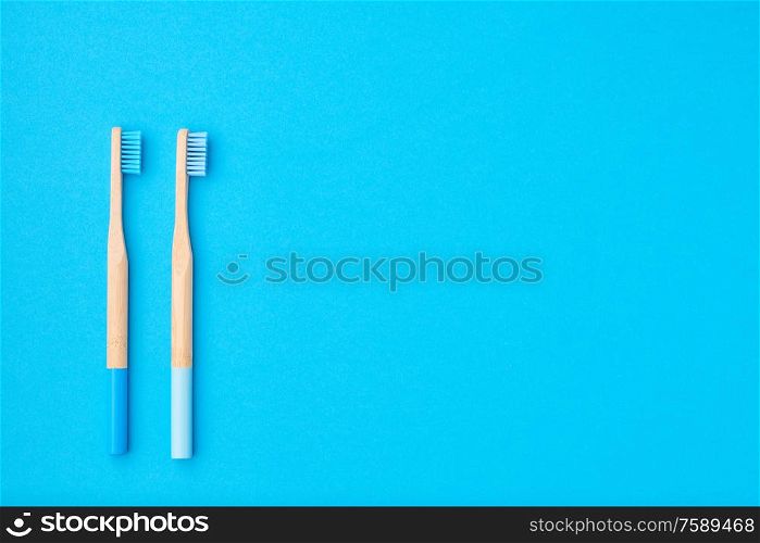 Toothbrushes on blue background top view copy space. Tooth care, dental hygiene and health concept.