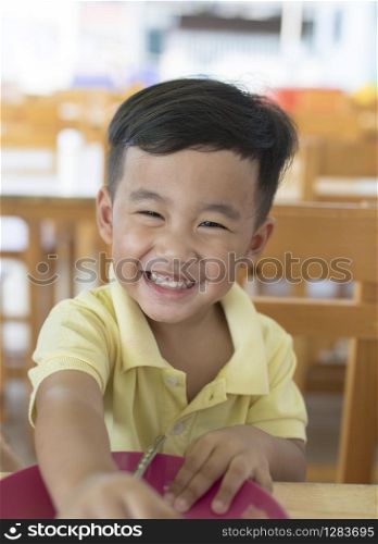 toothy smiling face happiness emotion of asian children sitting on food table