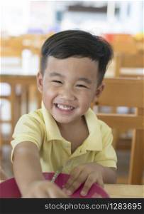 toothy smiling face happiness emotion of asian children sitting on food table