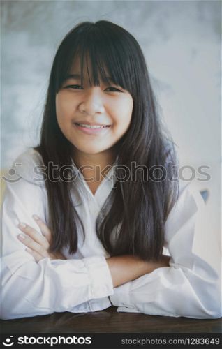 toothy smiling face of asian teenager looking with eye contact