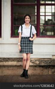 toothy smiling face of asian teenager standing outdoor
