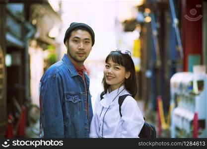 toothy smiling face of asian younger man and woman in city life location