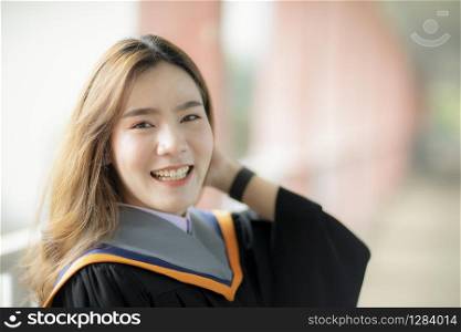 toothy smiling face of beautiful asian younger woman wearing university graduated clothes happiness emotion