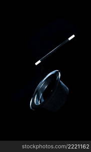 top black hat magic wand air against black background