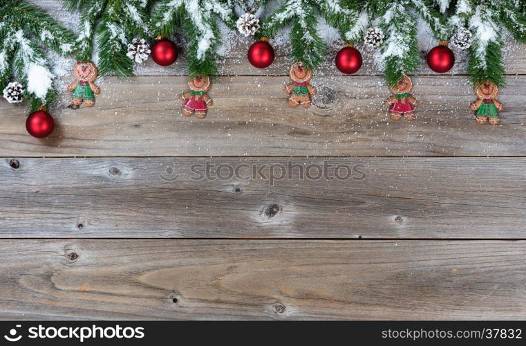 Top border of Christmas objects and snow on rustic wood for the holiday.