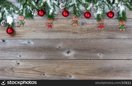 Top border of Christmas objects and snow on rustic wood for the holiday.