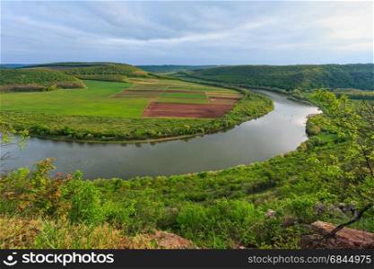 Top evening view of the Dnister river bend canyon, with spring fields on coast. Ternopil region, Ukraine, Europe.
