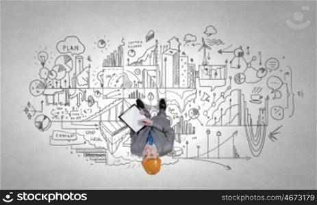 Top manager. Top view of a businessman with folder in hands and sketches on floor