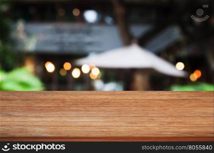 Top of brown wooden table with cafe blurred abstract background