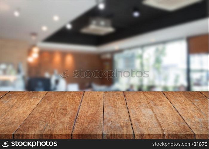 Top of perspective brown wooden with blurred cafe interior for background. product display template
